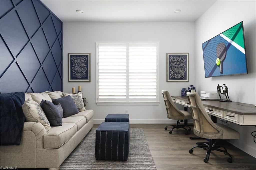 Accent wall featuring geometric paneling, sleeper sofa and two desks
