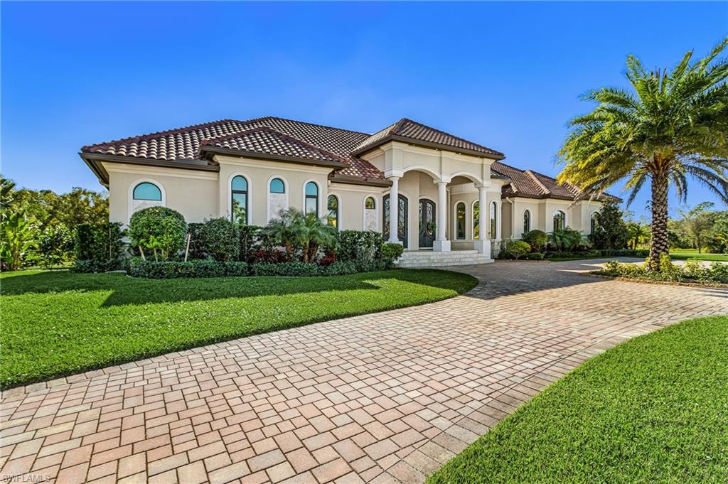 Mediterranean-style residence featuring a tile roof and stucco exterior