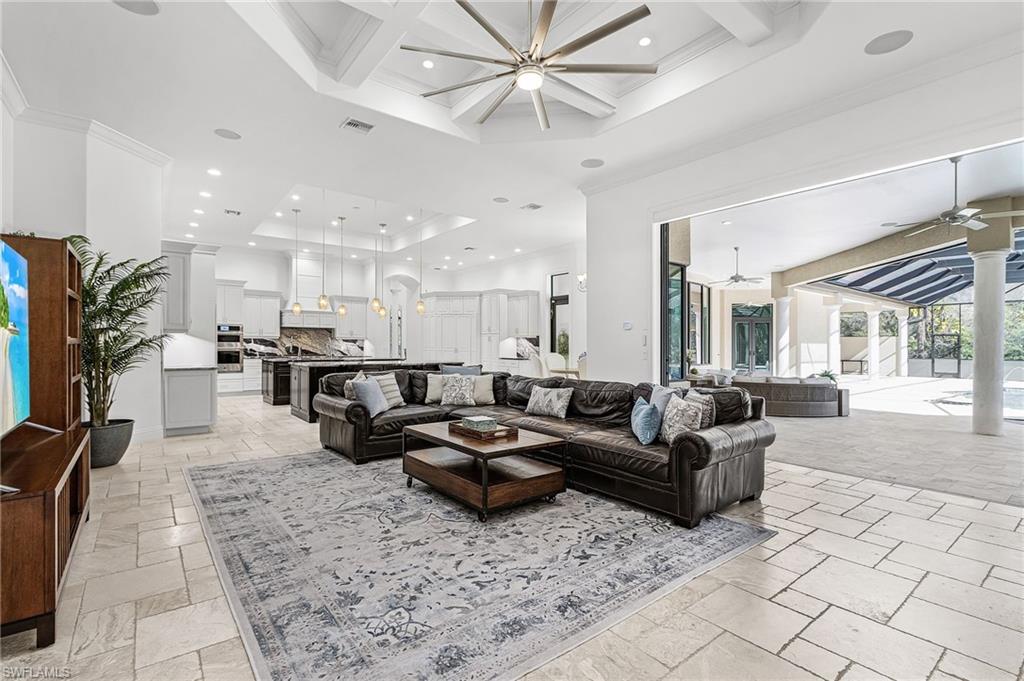 Spacious living area featuring coffered ceilings, recessed lighting, and large format tile flooring