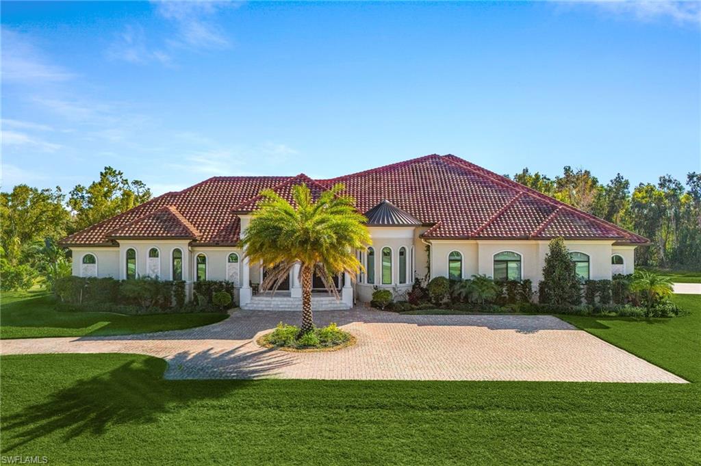 Mediterranean-style residence featuring a terracotta tile roof and light-toned stucco exterior