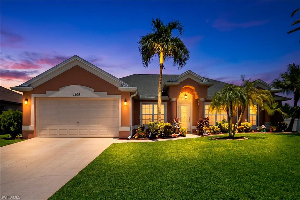 Mediterranean-inspired exterior with mature landscaping and multiple palm trees