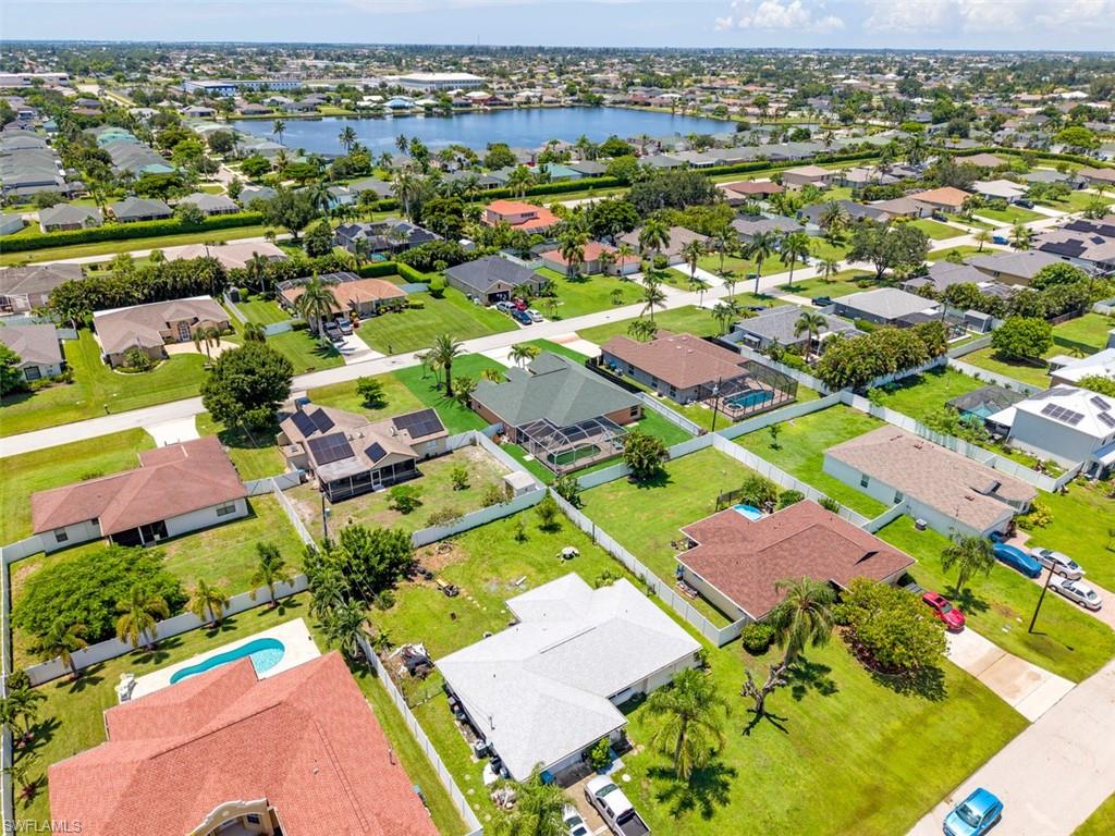 Aerial perspective of a residential community featuring mature landscaping and a prominent lake