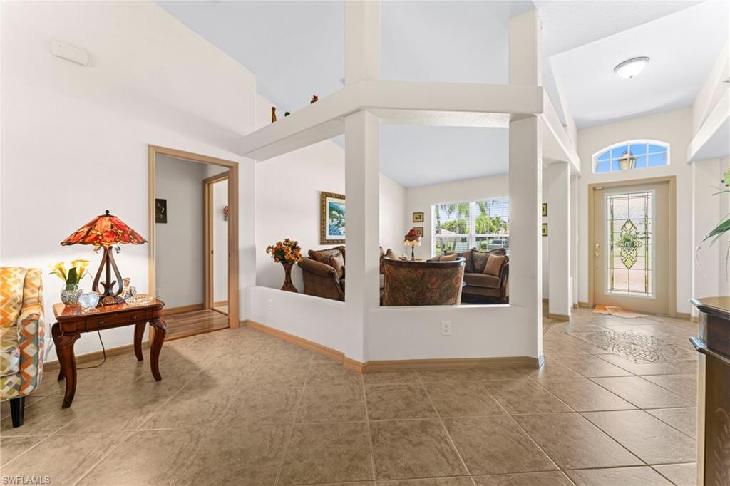 Tiled entryway featuring a decorative glass-paneled front door with an arched transom window