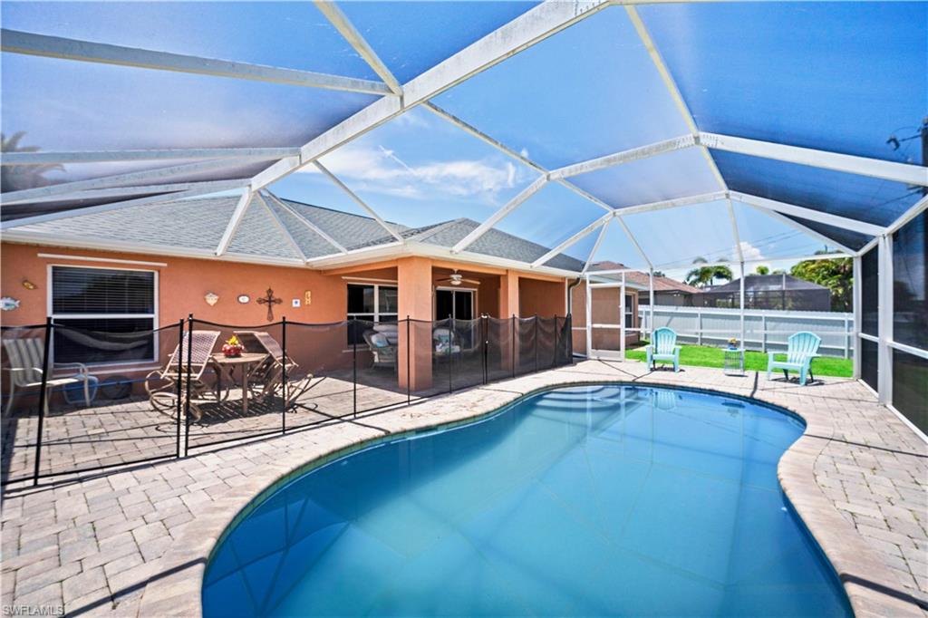 Screened lanai featuring a freeform pool, pavers, and a covered patio area