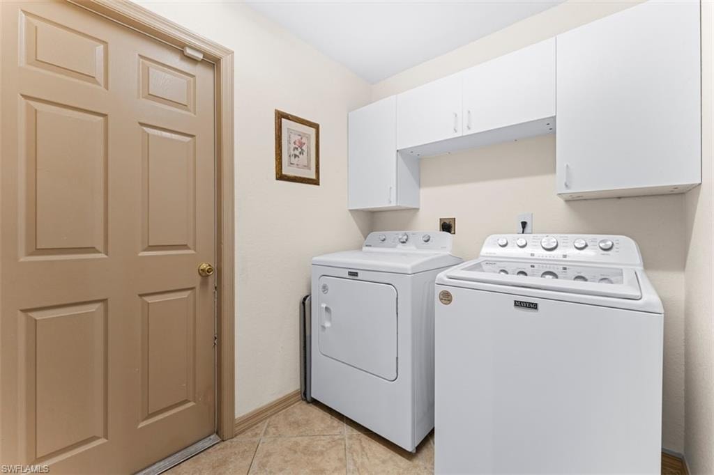 Functional utility area featuring white cabinetry providing overhead storage
