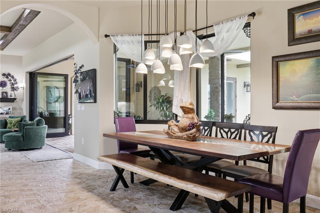 Dining area featuring a contemporary chandelier, a large window, and patterned tile flooring