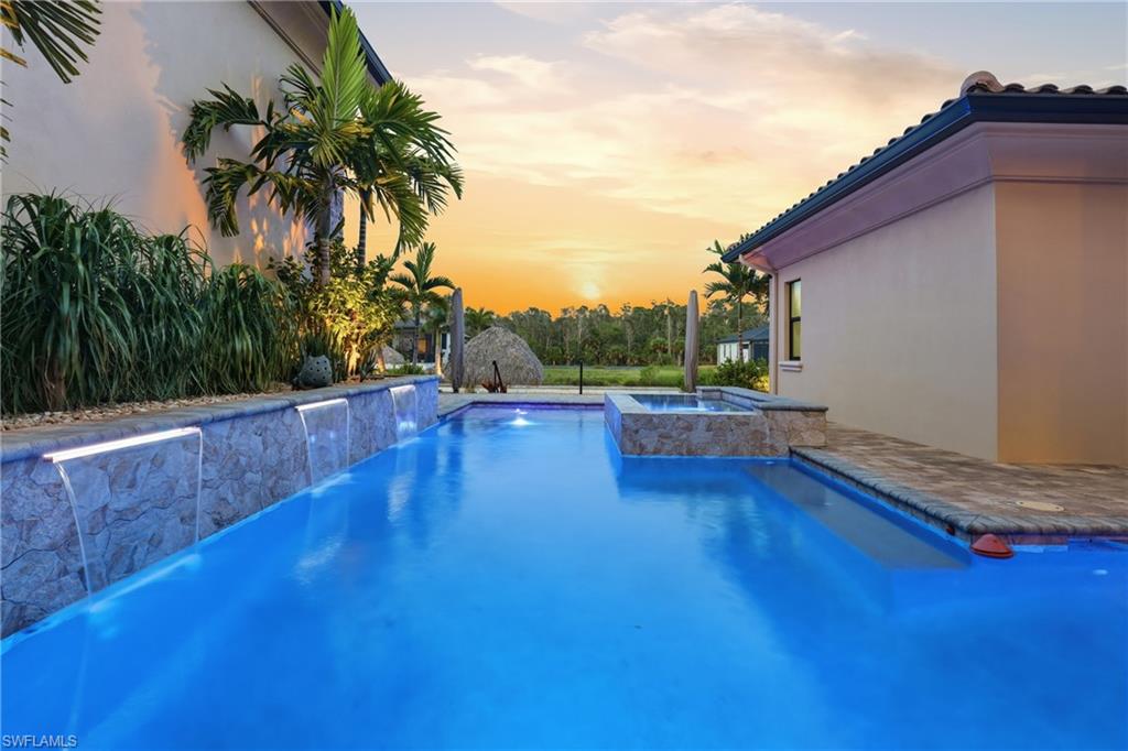 Custom swimming pool featuring multiple waterfall cascades and integrated spa