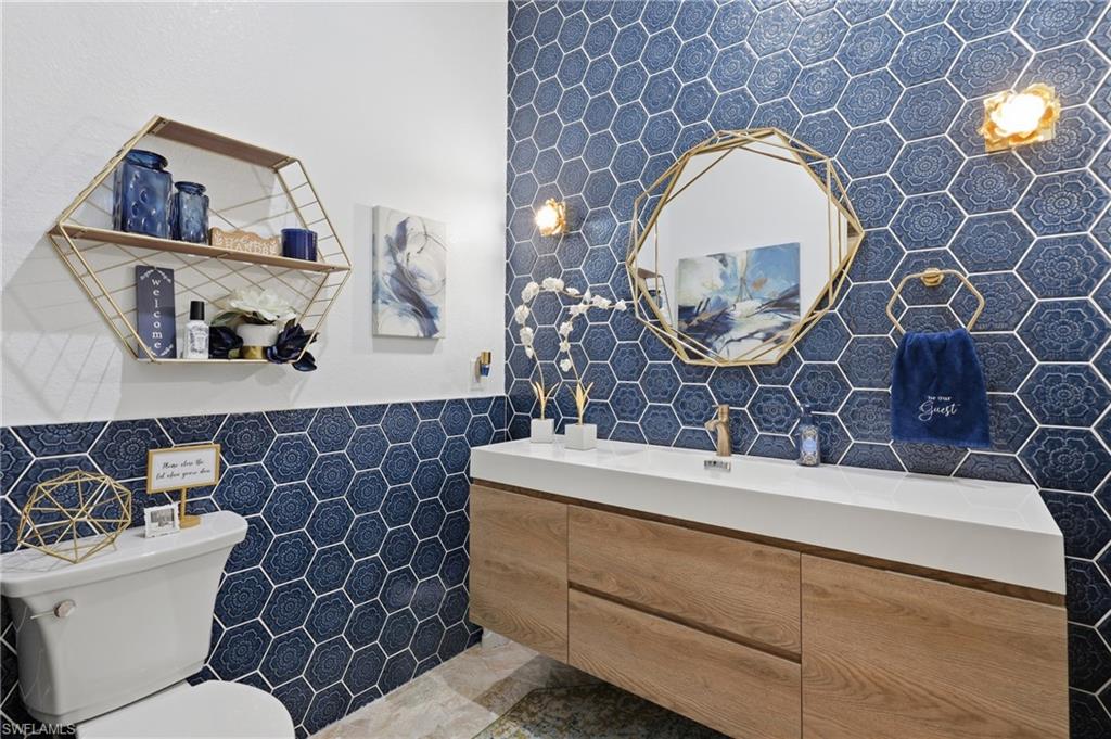Powder Room Accent wall featuring hexagonal blue tiles with a floral pattern