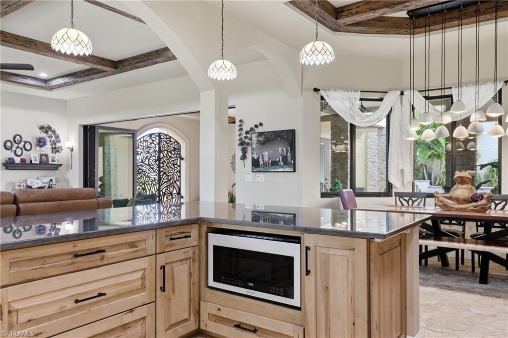 Central kitchen island with wood-finish cabinetry and a dark stone countertop