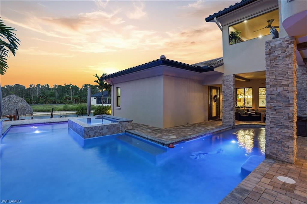 Outdoor living space featuring a swimming pool, integrated spa, and paver decking