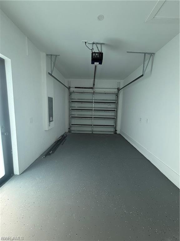 Garage interior featuring a gray speckled epoxy floor, white walls, and an automatic garage door opener
