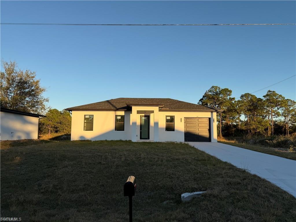 Contemporary single-story residence featuring a white exterior and a dark asphalt shingle roof