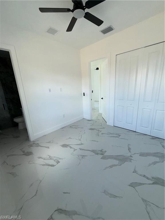 Room featuring marble-look tile flooring, white baseboards, and a black ceiling fan