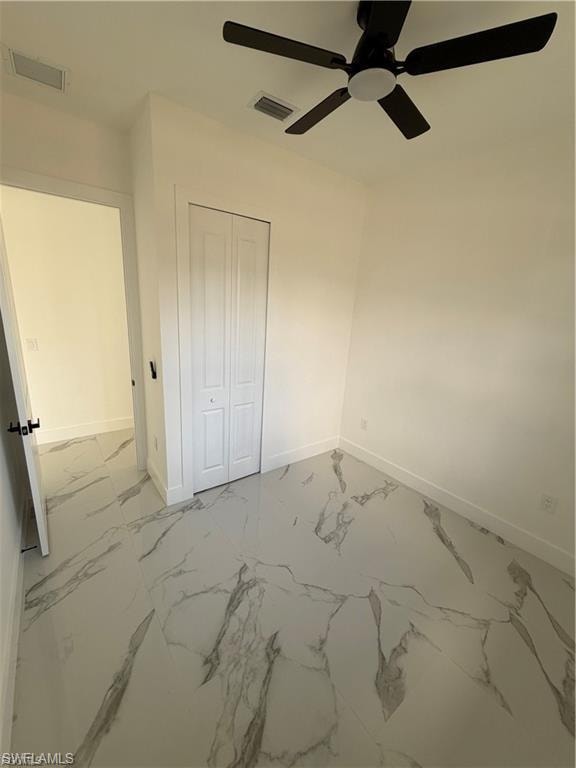 Room featuring large format marble-look tile flooring, a ceiling fan with integrated lighting, and a bi-fold closet door
