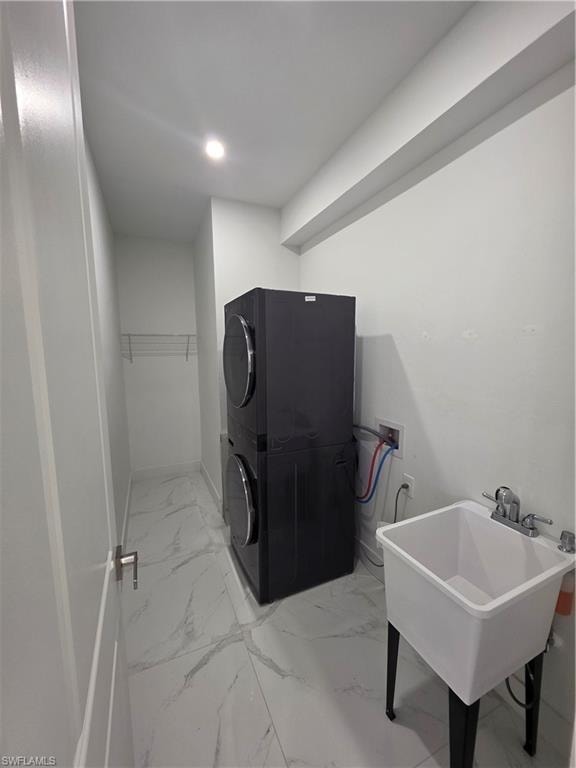 Dedicated utility space featuring marble-look tile flooring, white walls, and a recessed ceiling light