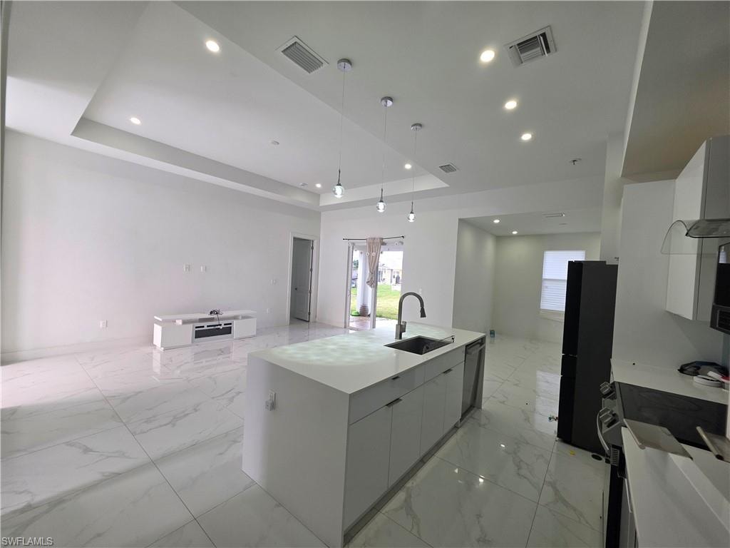 Open-concept living space featuring high ceilings, recessed lighting, and large format white tile flooring