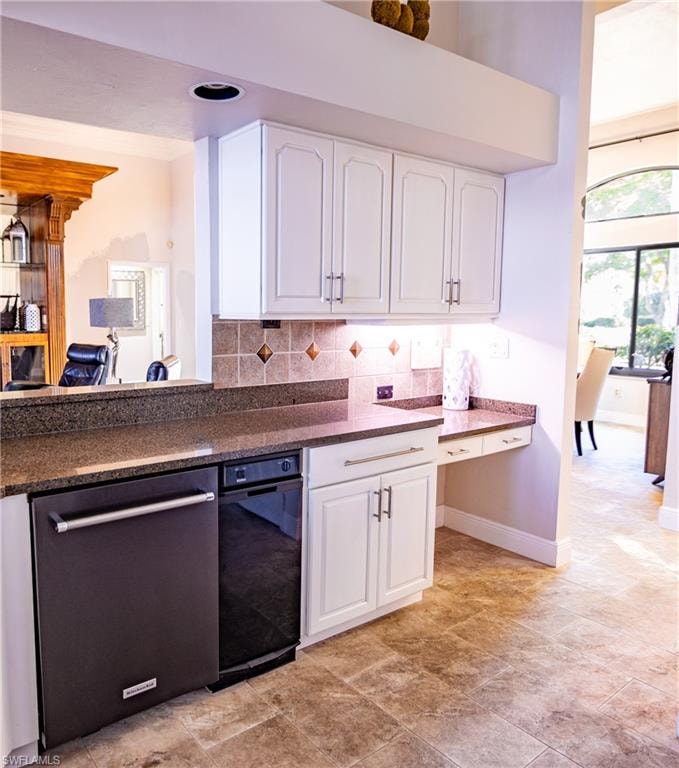 Kitchen featuring white upper and lower cabinetry, stone-finish countertops, tiled backsplash with decorative accents, and integrated appliances