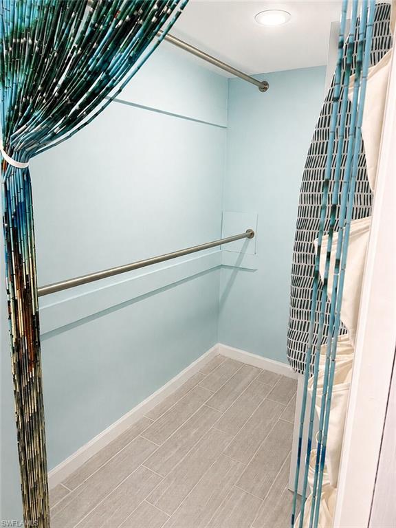 Recessed ceiling light, two chrome-finish hanging rods, and tile flooring - Virtually Edited Image