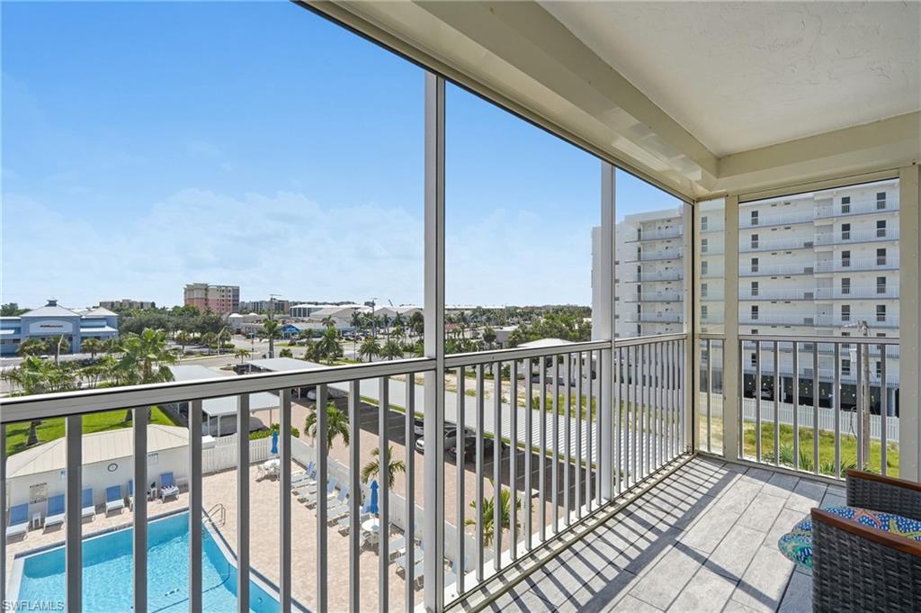 Expansive balcony with floor-to-ceiling glass panels and metal railing, offering panoramic vistas of the surrounding landscape - Virtually Edited Image