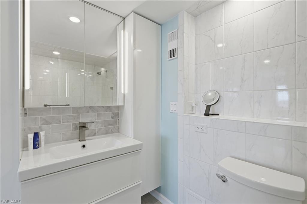 Modern bathroom featuring a floating vanity with rectangular vessel sink, quartz countertop, and chrome wall-mounted faucet - Virtually Edited Image