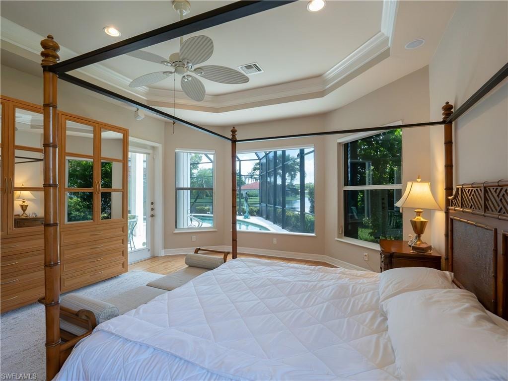 Tray ceiling with crown molding, recessed lighting, and a ceiling fan