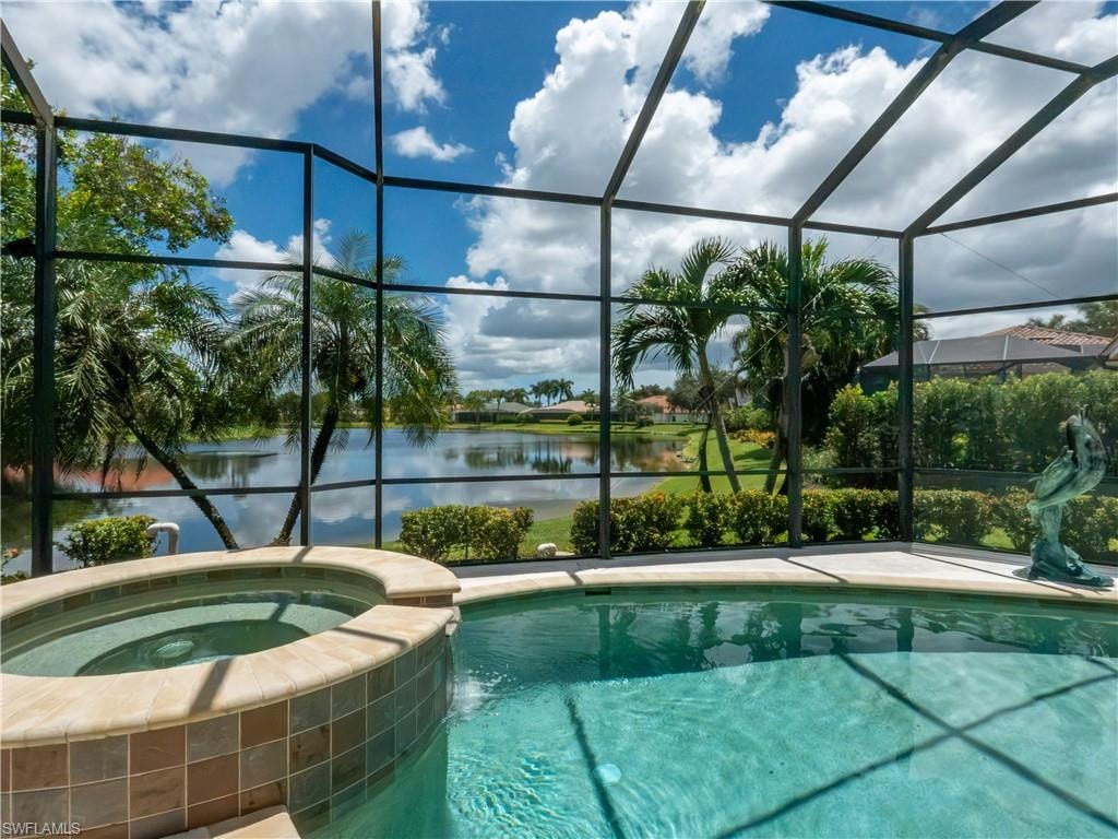 Screened enclosure featuring a tile-accented spa and an integrated pool, complemented by a water feature