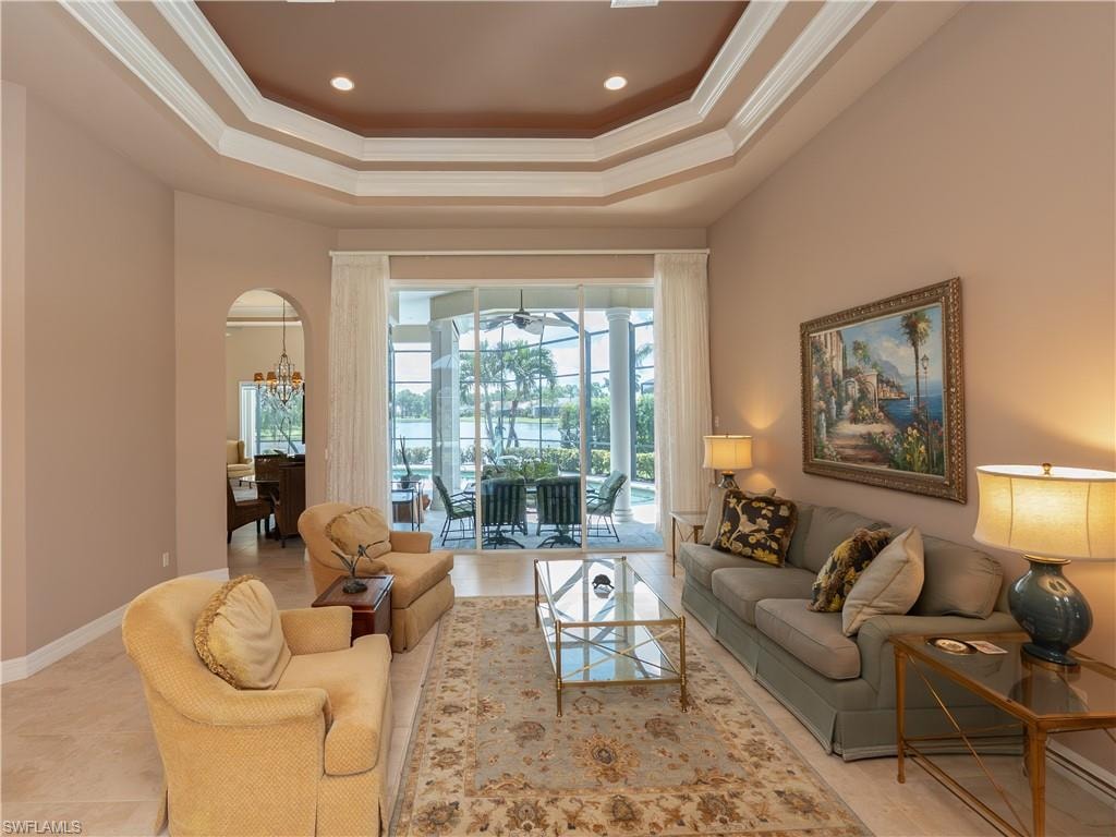 Recessed lighting, arched doorway, coffered ceiling, sliding glass doors, and tile flooring
