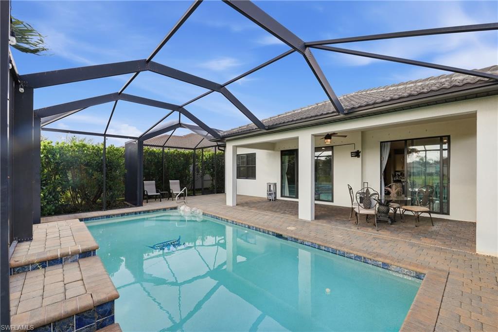 Screened enclosure housing a rectangular swimming pool with integrated steps
