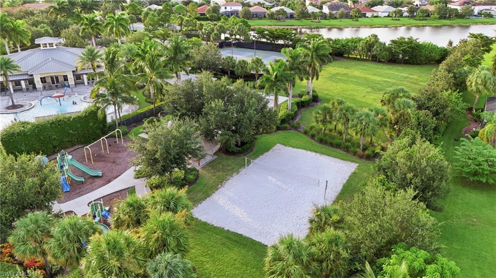 Community amenities featuring a sand volleyball court, playground with multiple slides, and a recreational building with an outdoor pool