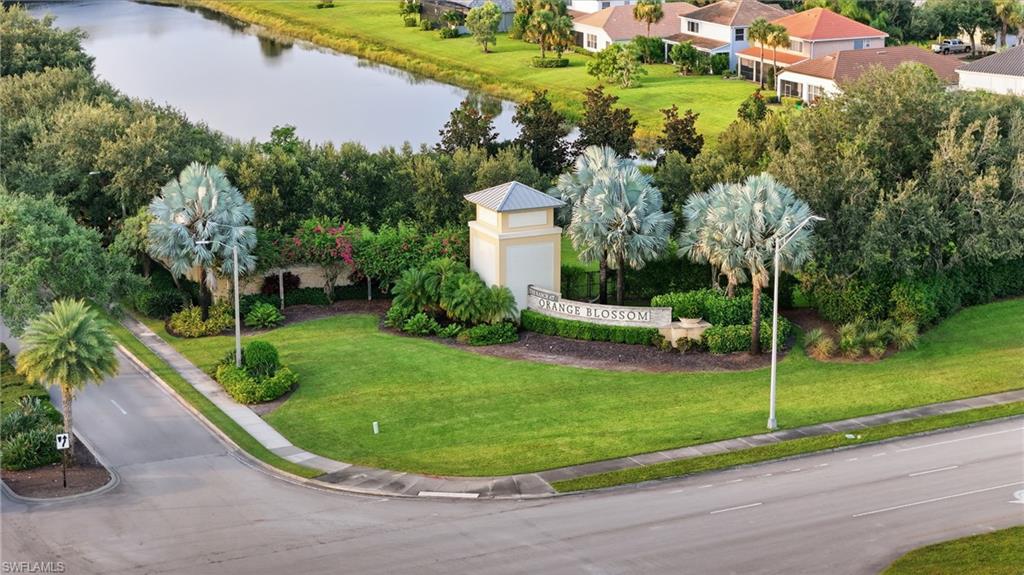 Impressive corner-lot entry featuring a manicured lawn with mature landscaping, including specimen trees with silvery foliage and established shrubs