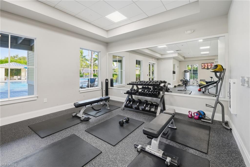 Fitness center featuring a large wall mirror, recessed lighting, and rubberized flooring