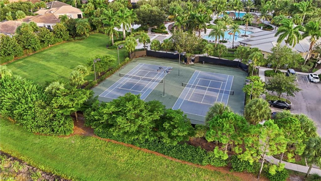 Twin hard-surface tennis courts with fencing and perimeter lighting