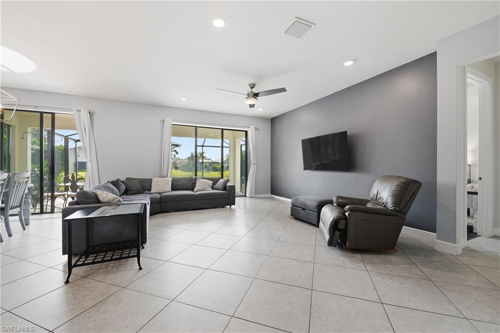 Open concept living area featuring light-toned tile flooring throughout and a contemporary ceiling fan