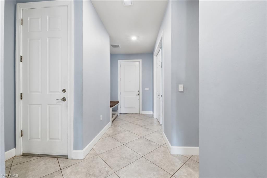 Entryway featuring light-toned tile flooring, recessed ceiling lighting, and white baseboards