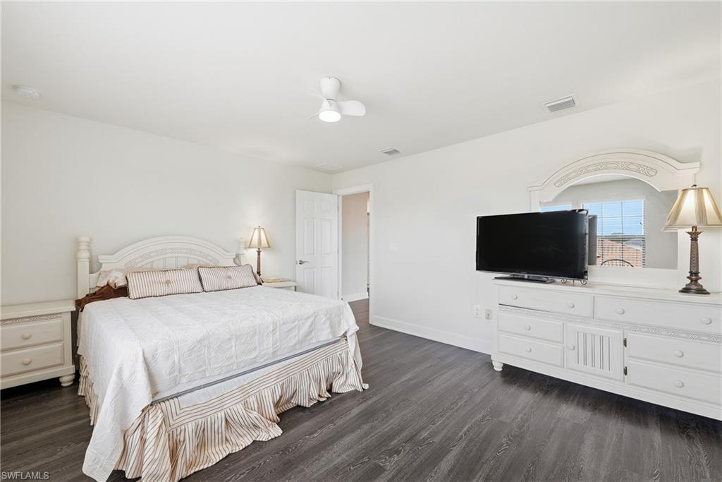 Spacious room featuring dark wood-finish flooring and light-toned walls