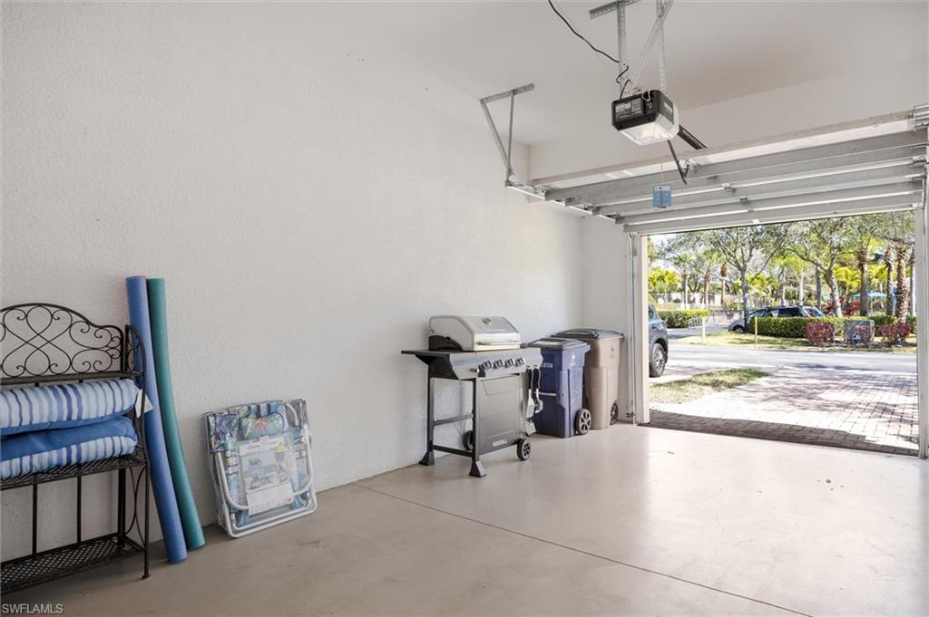 Garage interior featuring a light-colored concrete floor and white textured walls