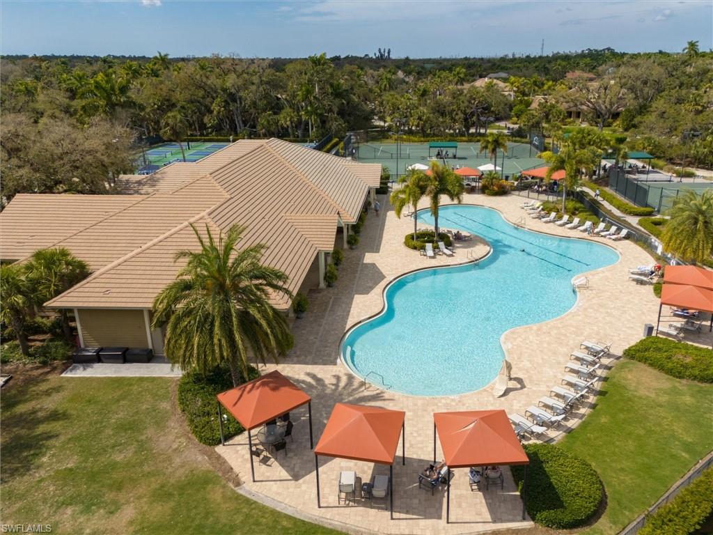 Expansive resort-style pool with integrated swim lanes, surrounded by a paved deck with lounge chairs