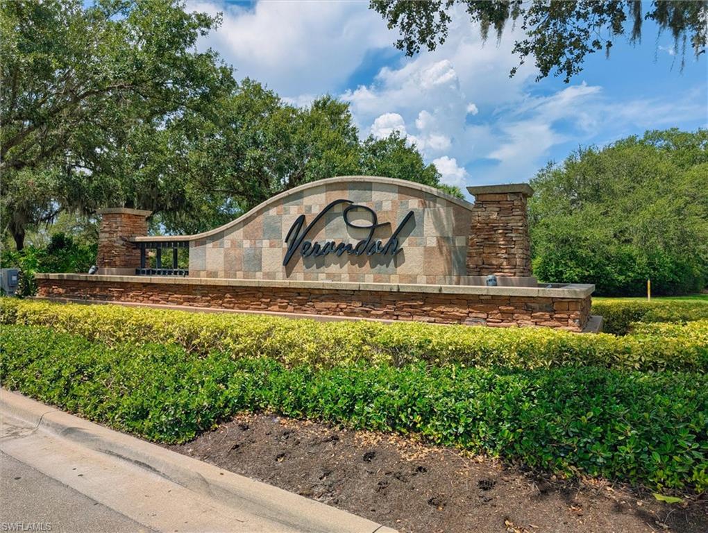 Community entrance sign featuring a curved stone facade with stacked stone accents