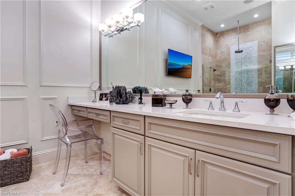 Spacious vanity with light-toned cabinetry, a built-in dressing table, and a large integrated sink