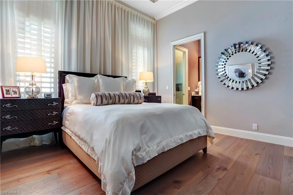 Spacious room featuring wide plank wood-finish flooring, crown molding, and plantation shutters