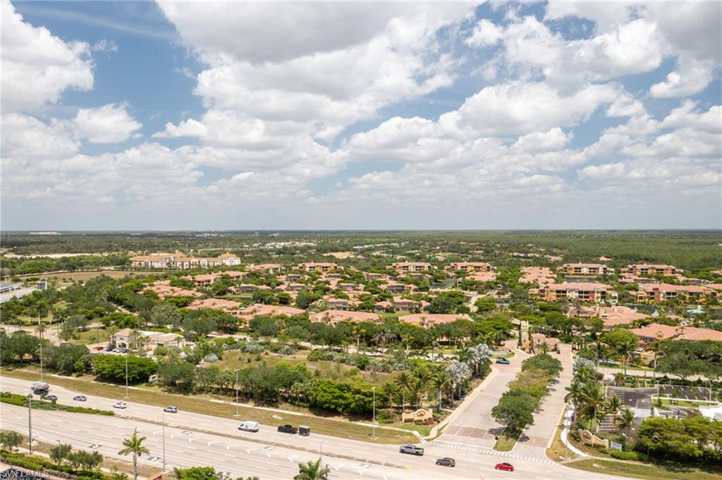 Expansive aerial perspective showcasing a residential community with numerous structures featuring terracotta-style roofing