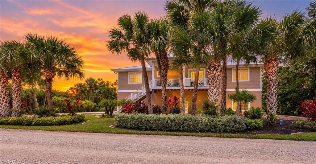 Multi-level residence featuring a tan exterior and white trim