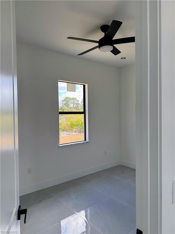Room featuring a window with an outdoor landscape, a black ceiling fan, recessed lighting, and grey tile flooring