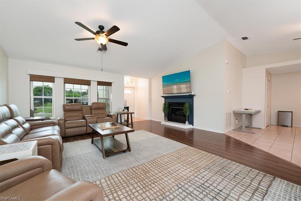 Bright Spacious Living Room with Fireplace & Sliders that open to the Pool Lanai area.