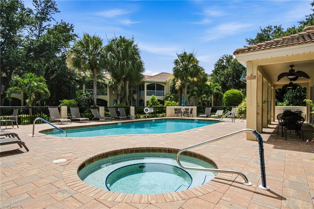 Expansive outdoor pool area featuring a rectangular pool, integrated spa, and surrounding paver decking