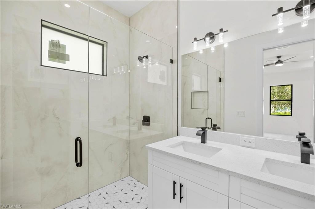 Contemporary bathroom featuring a spacious glass-enclosed shower with large format tile walls and a hexagonal mosaic floor
