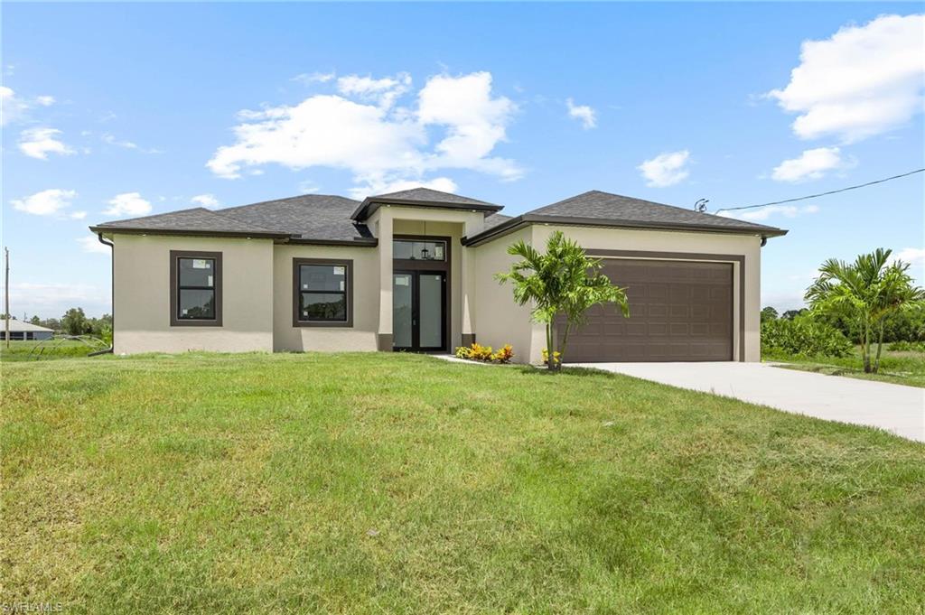Contemporary stucco exterior with a dark shingle roof, integrated two-car garage, front entry with double glass doors, and a concrete driveway