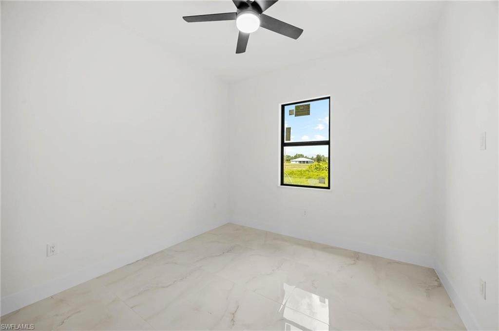 Bright room featuring a window with black trim, a ceiling fan with integrated lighting, and light-toned tile flooring