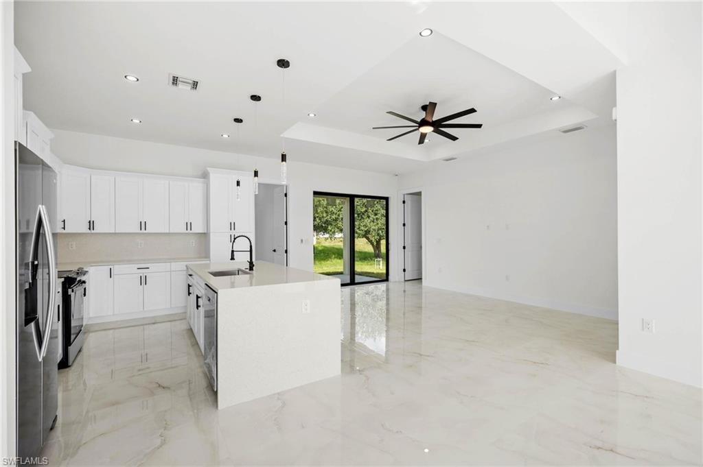 Open-concept living space with large format tile flooring and recessed lighting