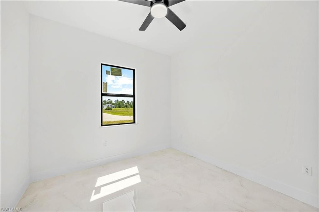 Bright room with a single black-framed window, white walls, and light-toned tile flooring
